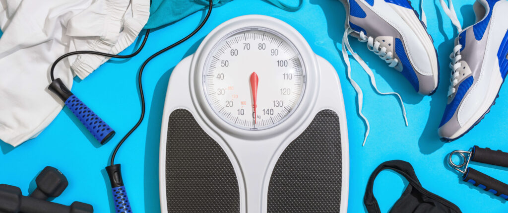 Waage und Sportausrüstung – BMI und Bewegung spielen eine wichtige Rolle bei Kinderwunsch und Fruchtbarkeit