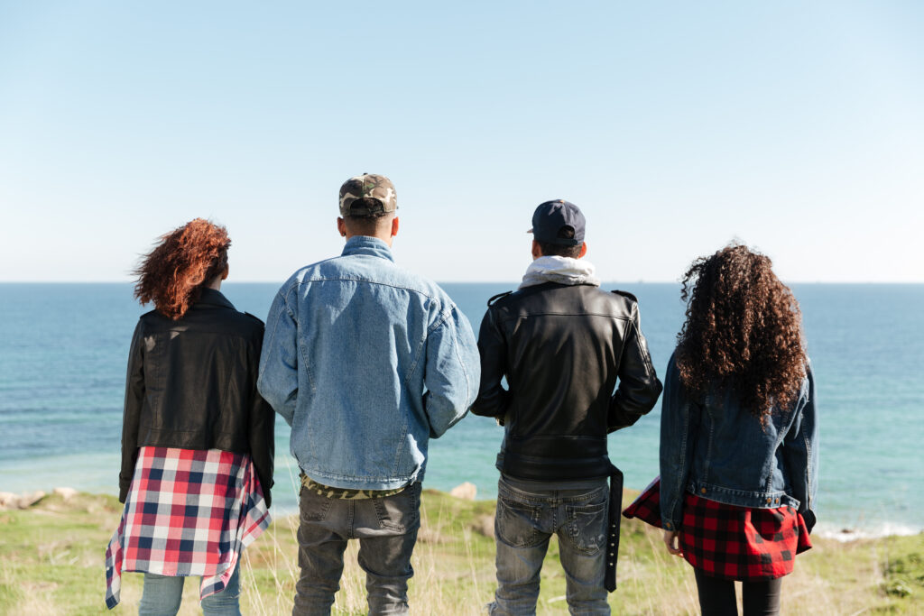 Drei Menschen von hinten, nebeneinander in die Weite blickend