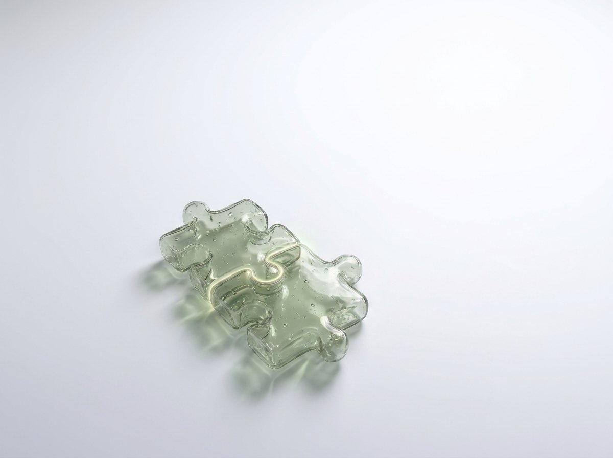 Zwei ineinandergreifende Puzzleteile aus salbeigrünem Glas