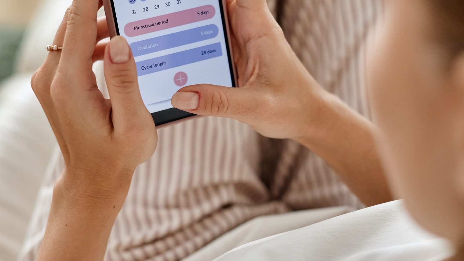 Frau verfolgt ihren Zyklus in einer App am Smartphone